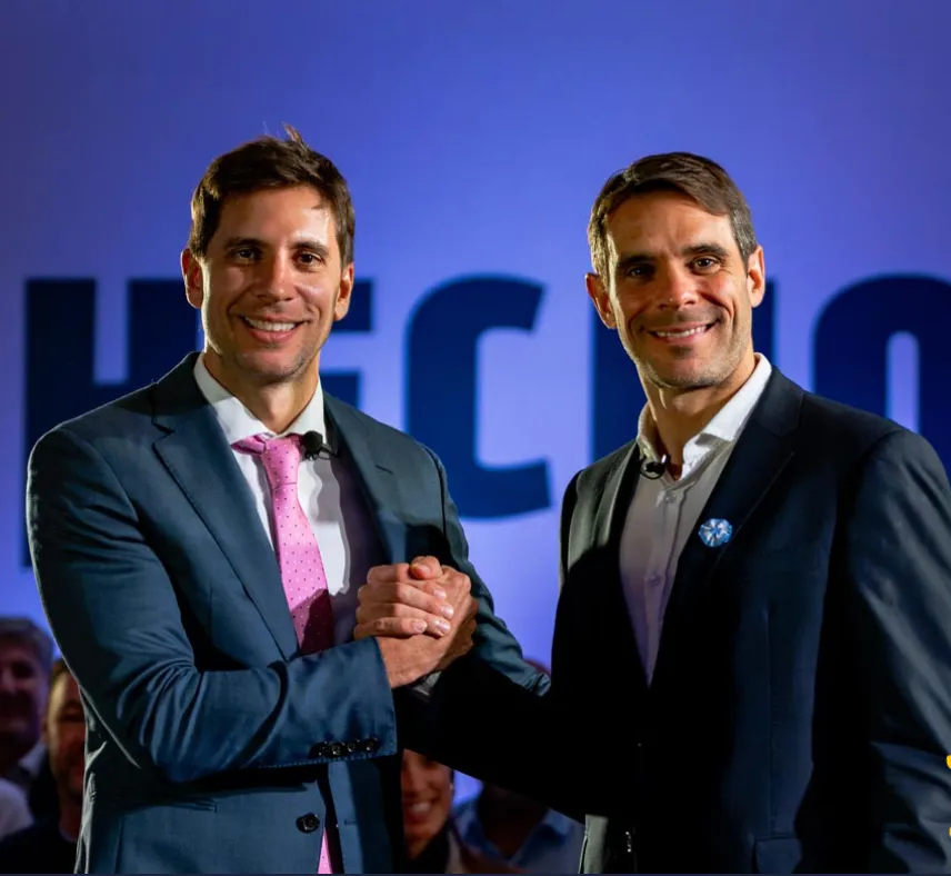 Santiago y Manuel Passaglia dándose la mano en un acto